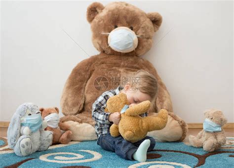孩子戴着防的医用口罩和生病的泰迪熊玩耍高清图片下载-正版图片506449910-摄图网