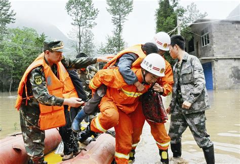 为控制水流，消防员洪水中筑成人墙运送沙袋