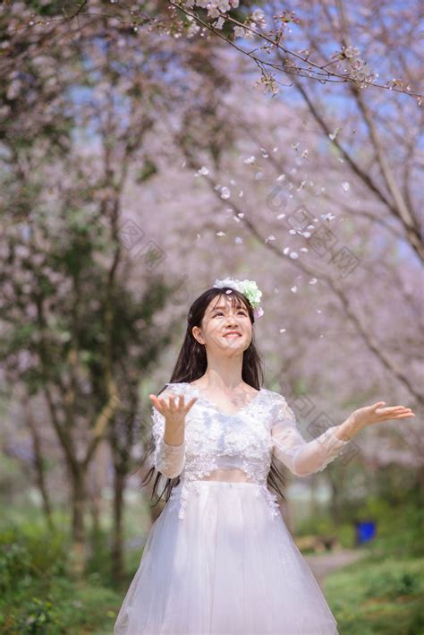 美丽的年轻亚洲女人在春天的樱花花园-包图企业站