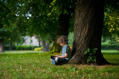 岁的男孩坐在一棵大树下高清图片下载-正版图片503244516-摄图网