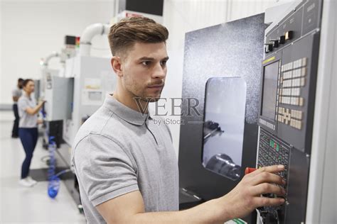 在工厂操作数控机械的男工程师照片摄影图片_ID:316940081-Veer图库