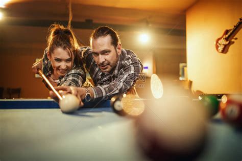 年轻的微笑开朗的夫妇下班后在酒吧打台球他们玩得开心并高清图片下载-正版图片504042892-摄图网