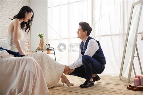 年轻的丈夫蹲下给妻子穿鞋高清图片下载-正版图片507655068-摄图网