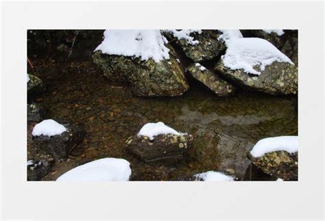 冬天溪水中的石块上覆盖着白雪下着小雪实拍视频素材下载_mp4格式_熊猫办公