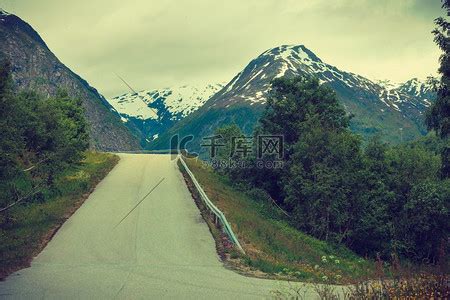 穿过挪威山脉的公路。山峦公路高清摄影大图-千库网