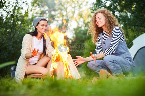 两个年轻女坐在营火边上晚上高清图片下载-正版图片505864100-摄图网