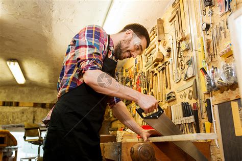 专业,木工,木工人的快乐的微笑木匠与锯木板车间工作高清图片下载-正版图片300609794-摄图网