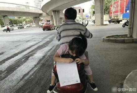 摩托车疾驰 后座女孩趴着做作业