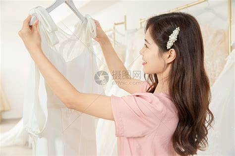 在婚纱店精心挑选婚纱的女孩高清图片下载-正版图片501655546-摄图网