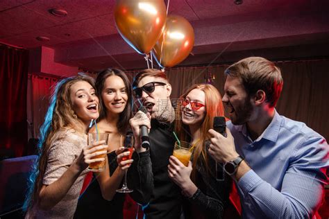 年轻又快乐的caucasian朋友在卡拉OK酒吧共聚晚宴一起唱歌和玩乐高清图片下载-正版图片503828389-摄图网