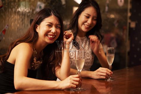 两位美丽的年轻女孩坐在酒吧里高清图片下载-正版图片506366705-摄图网