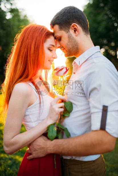 男子抱着手拿玫瑰的女友高清图片下载-正版图片302601751-摄图网