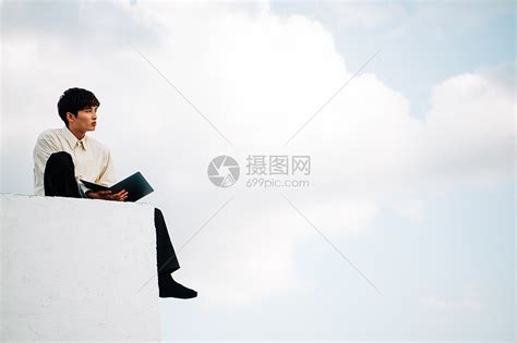 一个男人坐在屋顶上打开笔记本电脑高清图片下载-正版图片502251763-摄图网