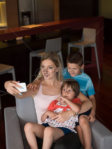 幸福的家庭坐沙发上,用手机家里打视频电话高清图片下载-正版图片300386846-摄图网