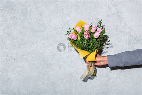 灰色背景下男人送花的特写视图高清图片下载-正版图片503125385-摄图网