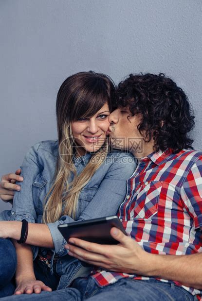 爱与休闲时间概念男人亲吻年轻女子并持有平板电脑高清图片下载-正版图片303572291-摄图网