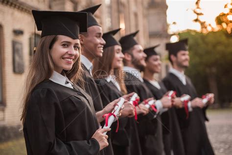 穿着学术礼服的成功毕业生拿着文凭高清图片下载-正版图片502615946-摄图网