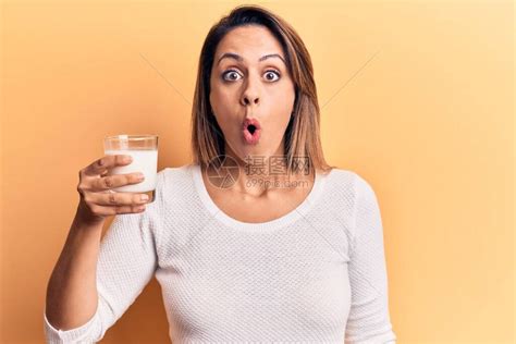 年轻美丽的女士拿着一杯牛奶害怕惊吓和惊异张开大口惊讶惊喜高清图片下载-正版图片504040915-摄图网