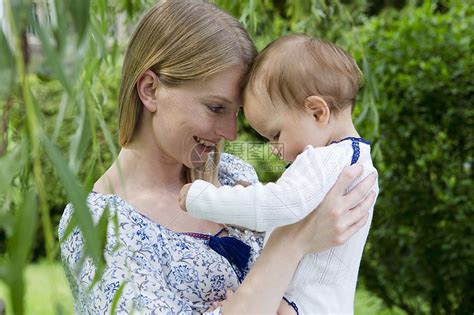 花园里抱着女婴的年轻母亲高清图片下载-正版图片501843485-摄图网