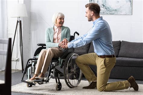 坐在轮椅上的残疾老年残疾妇女和微笑的男高清图片下载-正版图片502706640-摄图网