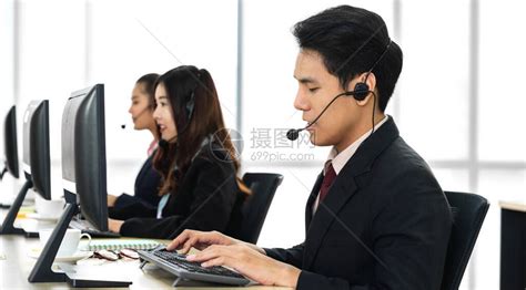 一群快乐的亚洲微笑呼叫中心业务运营商客户支持团队电话服务代理在呼叫中心的台式计算机上使用耳高清图片下载-正版图片506678168-摄图网
