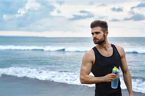 大海边拿着水瓶的肌肉型男摄影图片 - 三原图库sytuku.com