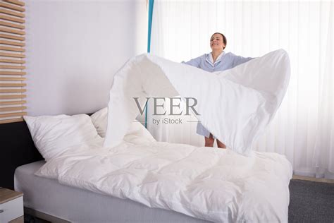 管家整理床单在床上照片摄影图片_ID:317527321-Veer图库