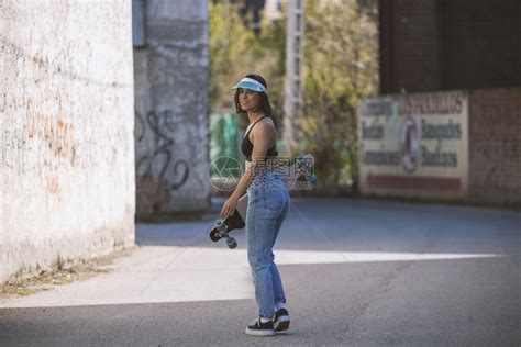 感的运动鞋瘦骨嶙峋的女孩与她滑冰在镇路上高清图片下载-正版图片307645111-摄图网