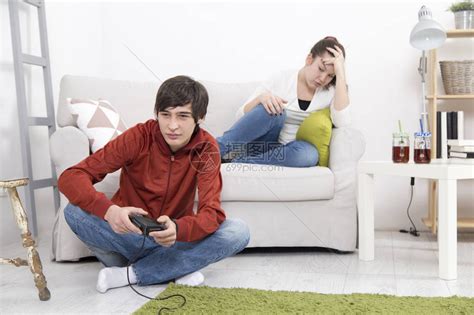 女孩是无聊和生气时男友玩视频游戏高清图片下载-正版图片502451655-摄图网