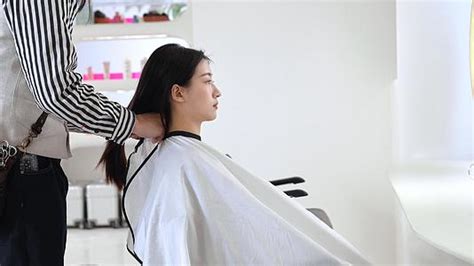一名男子正在美发厅接受女发型师的理发视频素材_ID:VCG42N1296163298-VCG.COM