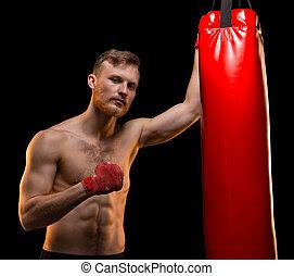 Young man flexing muscles with punching bag. close-up. | CanStock