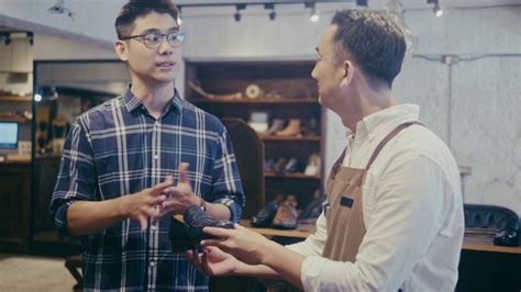 亚洲鞋店店员在柜台上与顾客交谈(慢镜头)视频素材_ID:VCG42N1171704836-VCG.COM