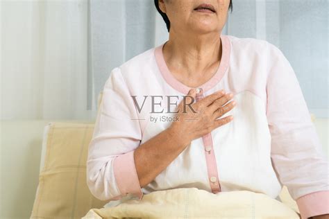 心脏病发作的老奶奶抱着胸口躺在床上，老年观念的保健问题照片摄影图片_ID:374264201-Veer图库