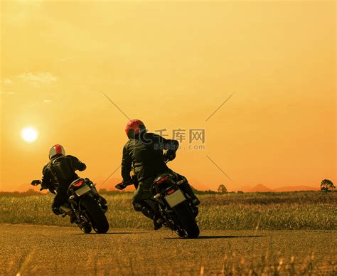 情侣朋友摩托车骑手再次在沥青公路上骑自行车高清摄影大图-千库网