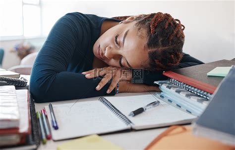 精疲力竭，学生在课桌上睡觉，在房间里学习、阅读或大学教育知识时拿着书本。高清摄影大图-千库网