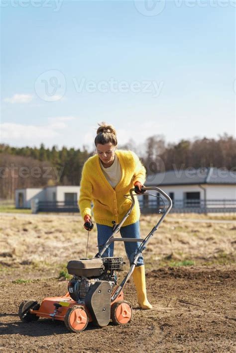 Woman villager is using aerator machine to scarification and aeration ...
