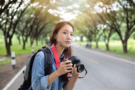 爱好镜片头发女摄影师在野外拿着摄像头拍旅游者的照片来自游客高清图片下载-正版图片308012358-摄图网
