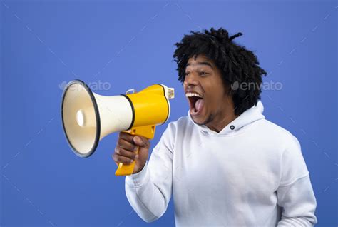 Cool news. Agitated African American teen guy screaming into megaphone ...
