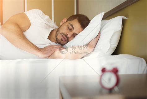 英俊男人睡在酒店房间床高清图片下载-正版图片505325020-摄图网