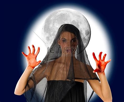 女人带着黑色的面纱和血淋淋的手，背景是一个大月亮高清摄影大图-千库网