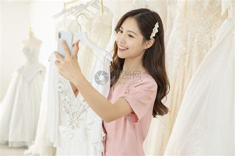 在婚纱店挑选婚纱的女孩高清图片下载-正版图片501654681-摄图网