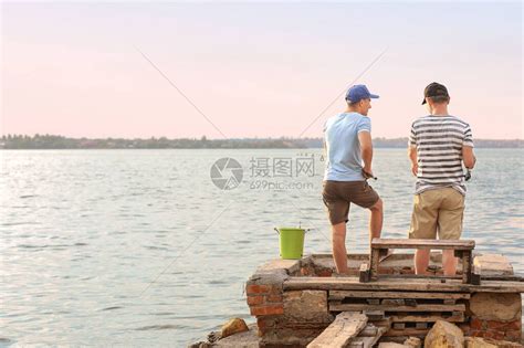 年轻人和他的父亲在河边钓鱼高清图片下载-正版图片506288907-摄图网