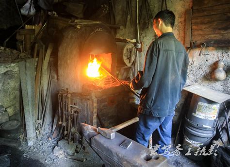 女金属艺术家从一个传统烧焦的铁匠炉中挑出一个工作器件高清图片下载-正版图片506428255-摄图网