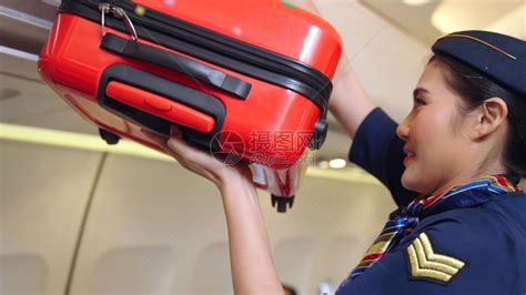 航空空姐在帮助乘客放行李箱高清图片下载-正版图片306623043-摄图网