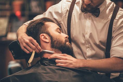时尚的理发师在理发店理发胡子男子在沙龙理-包图企业站