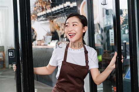 咖啡店门口迎接顾客的女服务员高清摄影大图-千库网