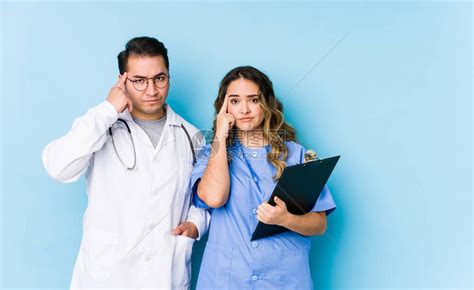 年轻医生夫妇在蓝色背景中装扮高清图片下载-正版图片503834890-摄图网