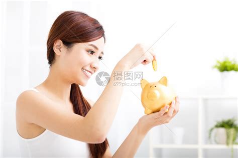 幸福的年轻女人在储钱罐存钱高清图片下载-正版图片502447468-摄图网
