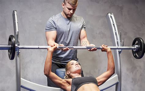 运动,健身,队合作人的轻的女人私人教练健身房机器上弯曲肌肉高清图片下载-正版图片300606735-摄图网