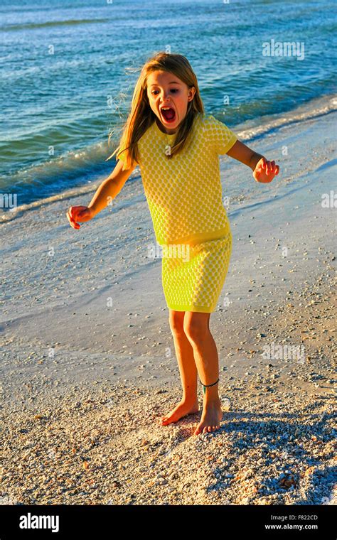 Young pre-teen girl screams aloud as she steps on s sharp seashell at ...